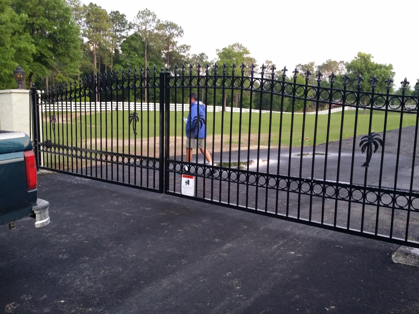 ornamental double estate gate with automatic opener system at residential entrance