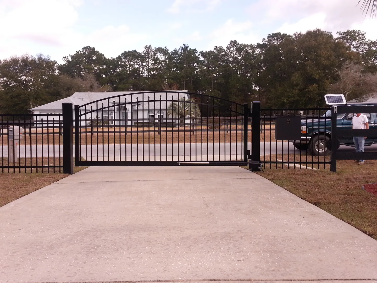 automatic sliding metal estate gate with gate opener at residential driveway