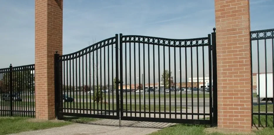 black metal estate gate installed at wide property entrance with dual swing design