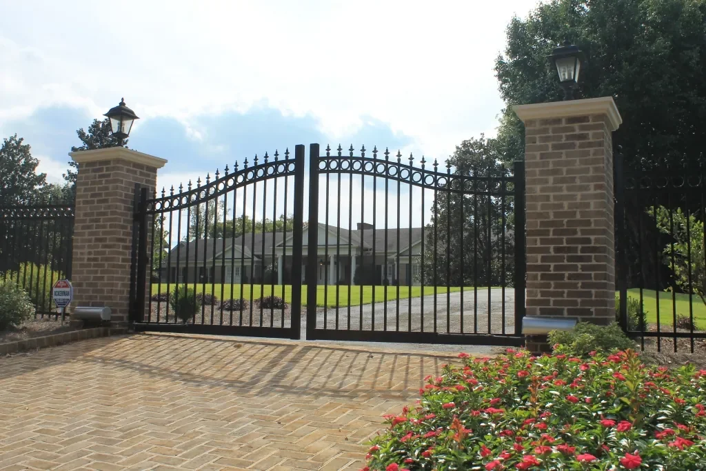 ornamental metal estate gate with brick columns at residential driveway entrance
