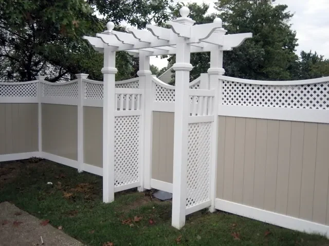 White vinyl privacy fence with lattice top and decorative pergola gate installed in a residential backyard in Florida