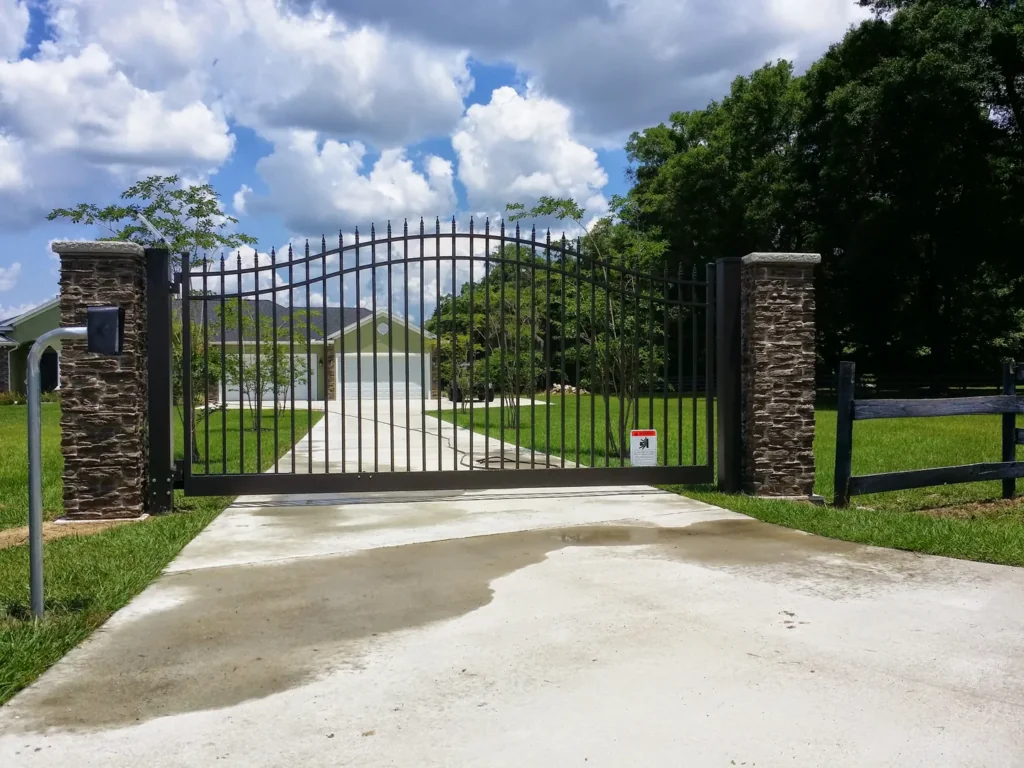 metal estate gate with stone columns at upscale residential driveway entrance